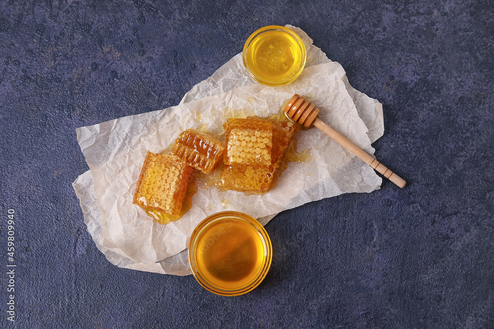 Bowls of honey and combs on black background