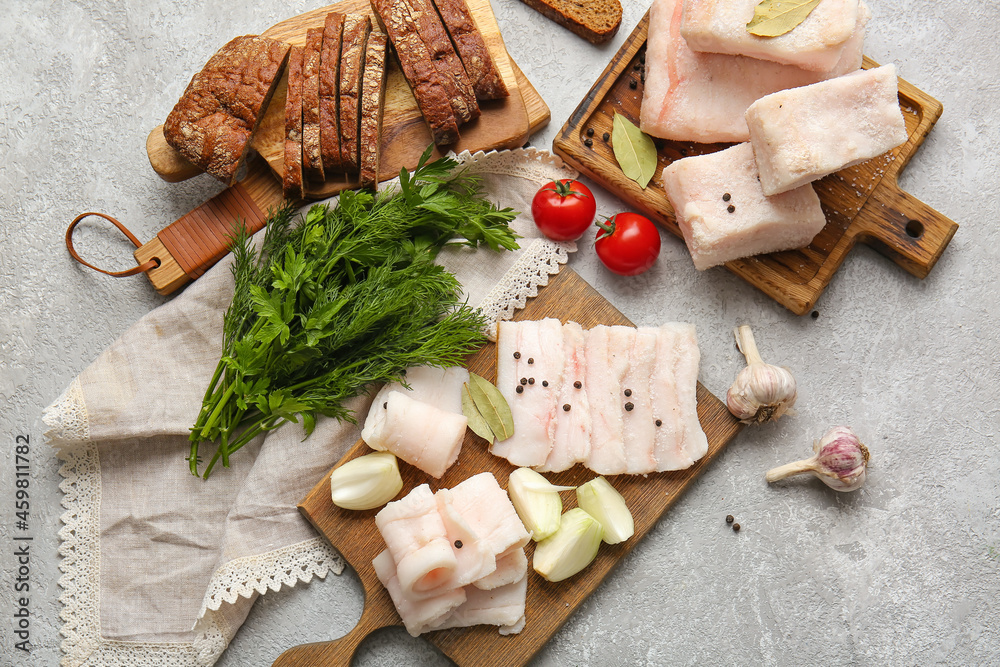 Wooden boards with salted lard on light background