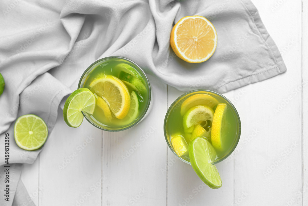 Glasses with tasty lemonade on light wooden background