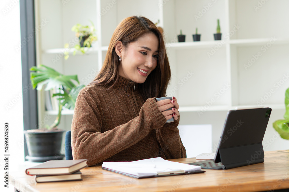 美丽微笑的亚洲女博主穿着休闲服坐在木头上用笔记本电脑