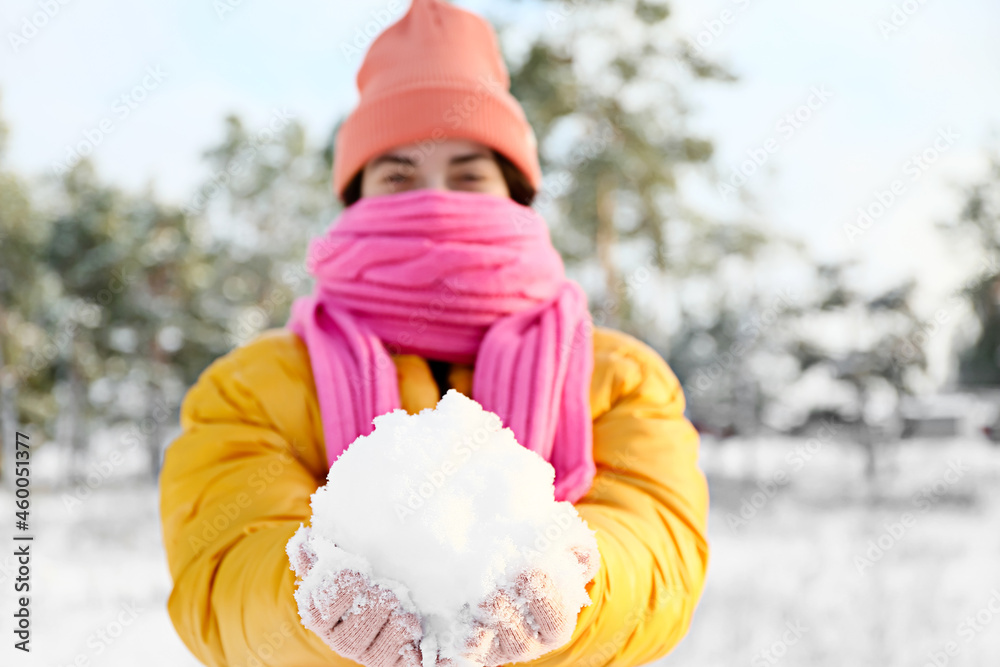 Young woman playing with snow on winter day