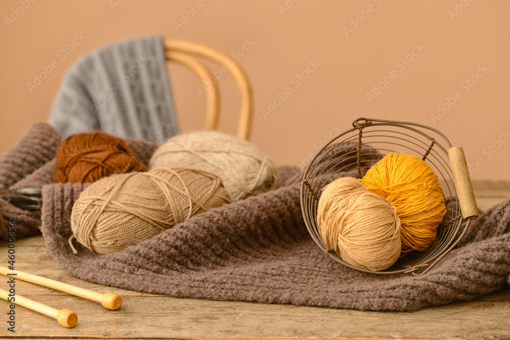 Knitting yarn, needles and plaid on wooden table