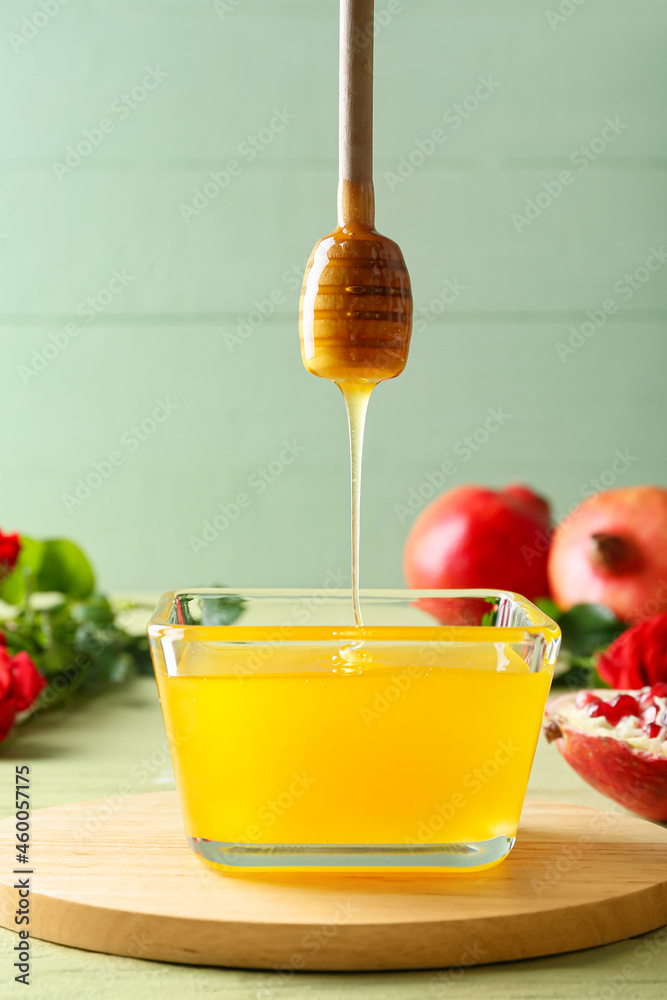 Honey pouring from dipper into bowl on table