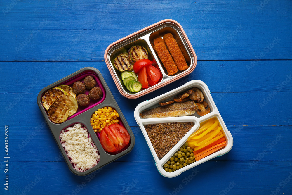 Containers with food on blue wooden background