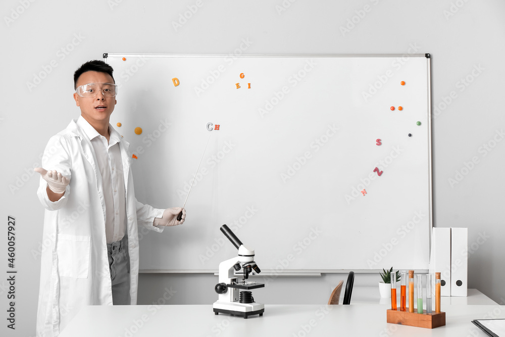 Asian teacher conducting chemistry lesson