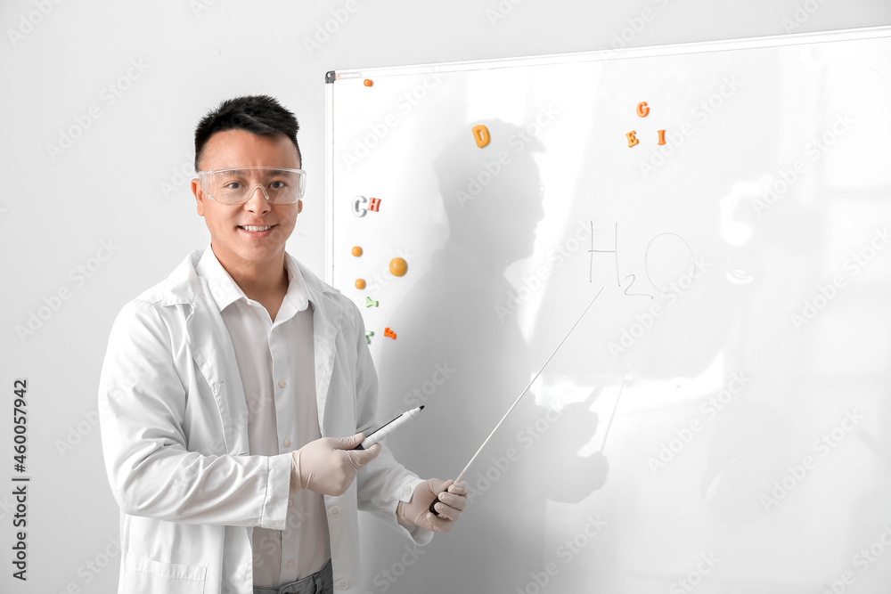 Asian teacher conducting chemistry lesson