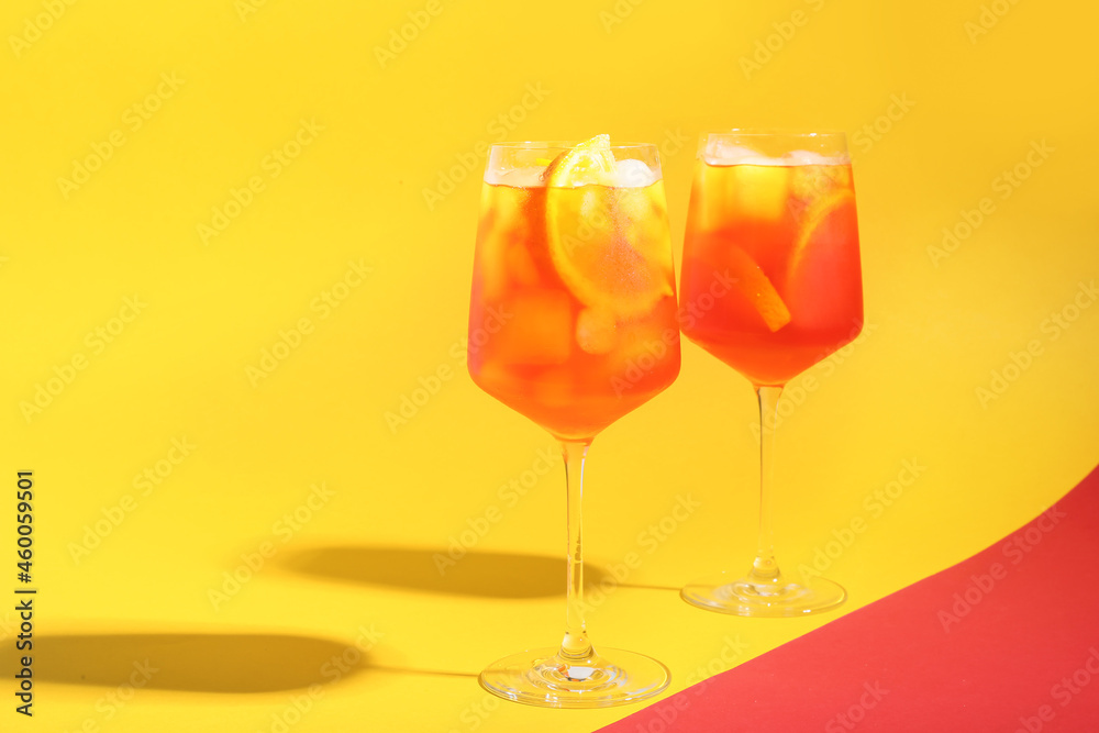 Glasses of Aperol spritz cocktail on color background