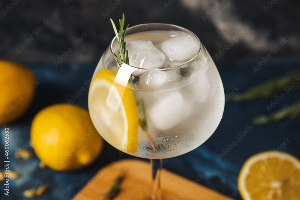 Glass of cold gin tonic on dark background