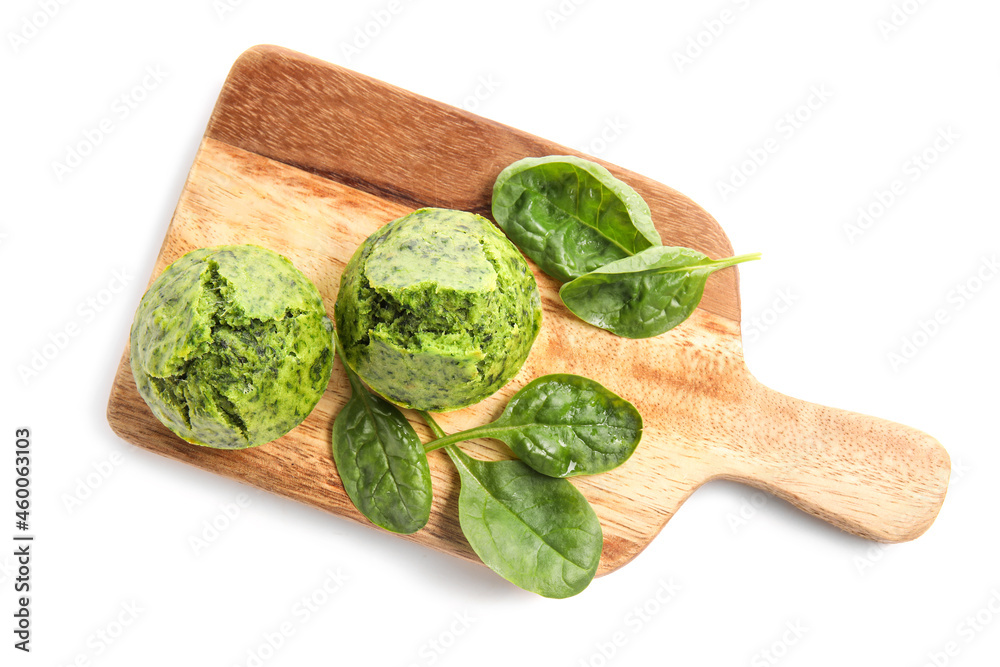 Wooden board with tasty spinach muffins on white background