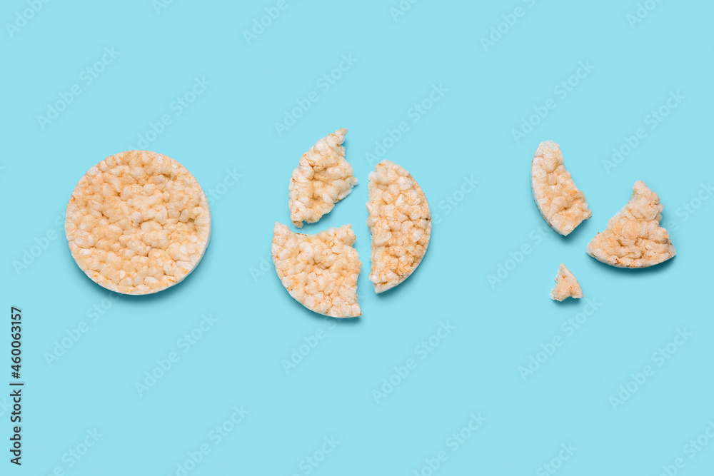 Broken puffed rice crackers on color background