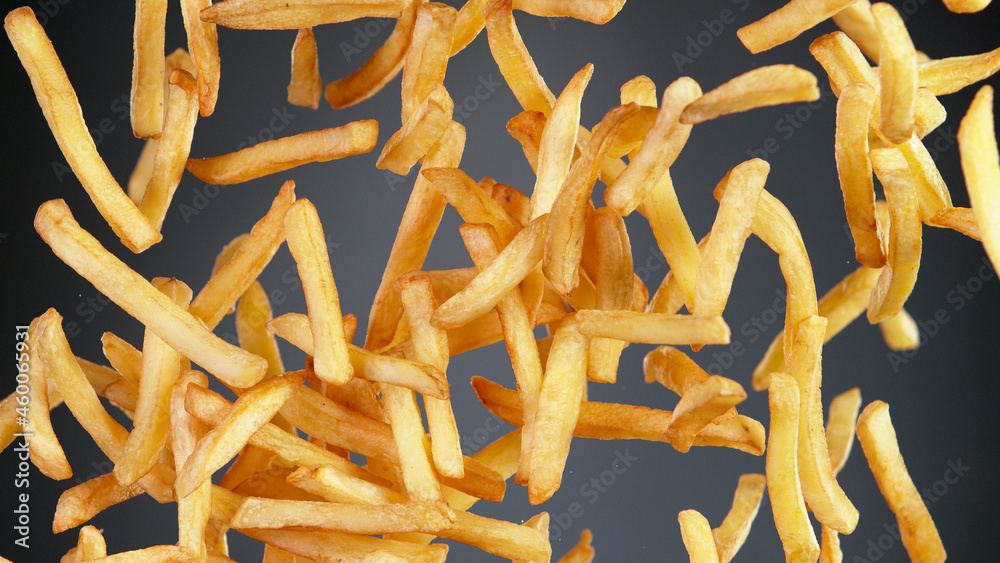 Freeze motion of flying french fries on black background