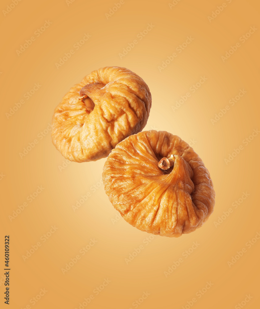 Dried figs close up in the air on a yellow background