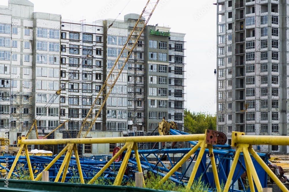 大型建筑工地，包括在建筑群上工作的几台起重机，天空晴朗