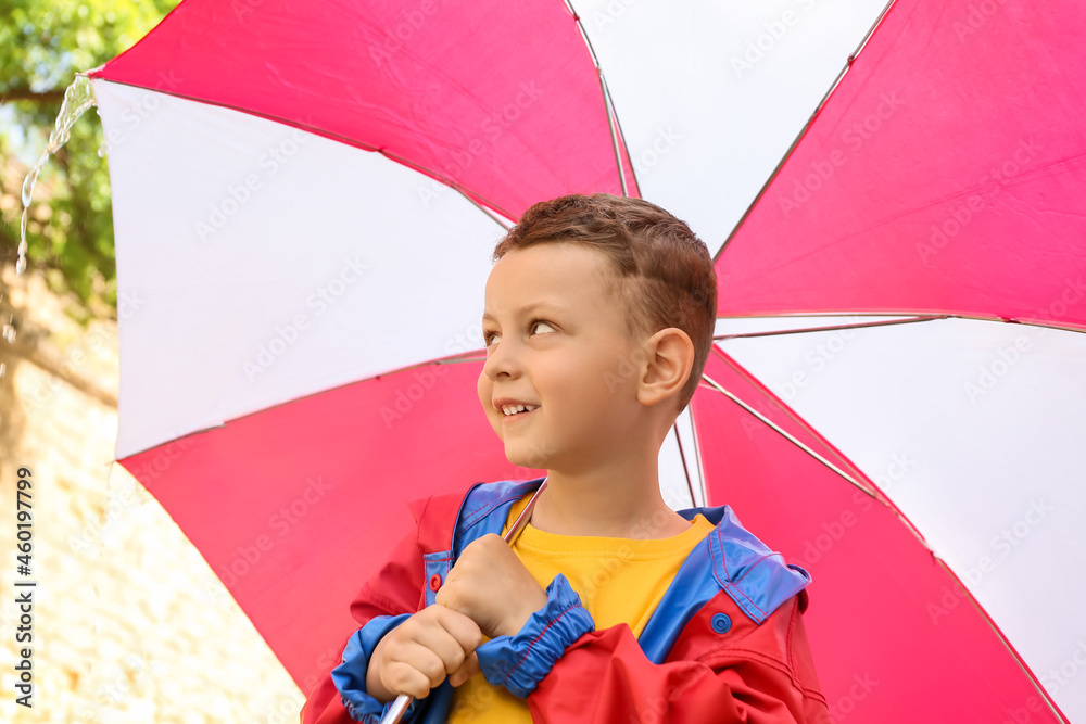 Cute little boy with umbrella outdoors on rainy day