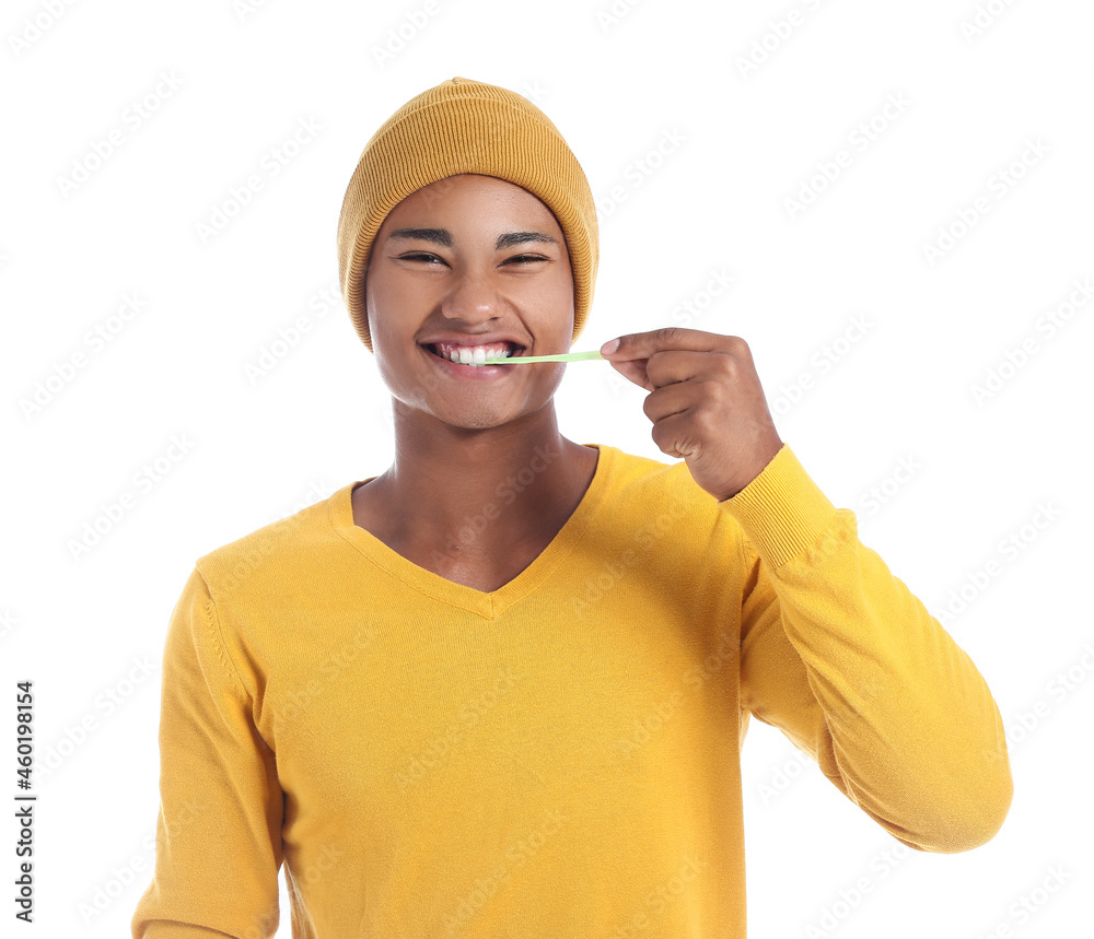 Happy African-American guy with chewing gum on white background