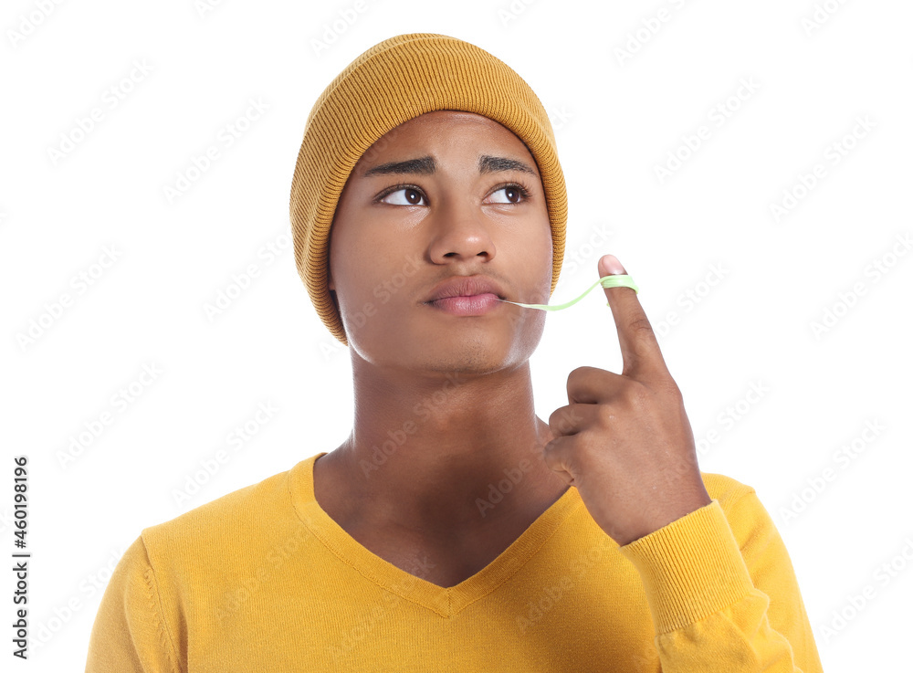 Sad African-American guy with chewing gum on white background