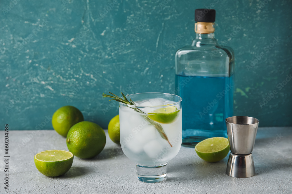 Glass of cold gin tonic on color background