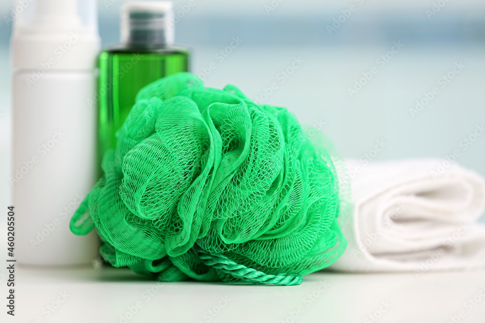 Bottles of cosmetic products and sponge on table, closeup