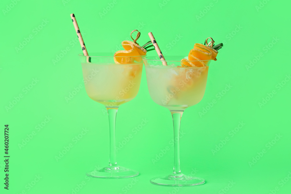 Glasses of cold melon cocktail on green background