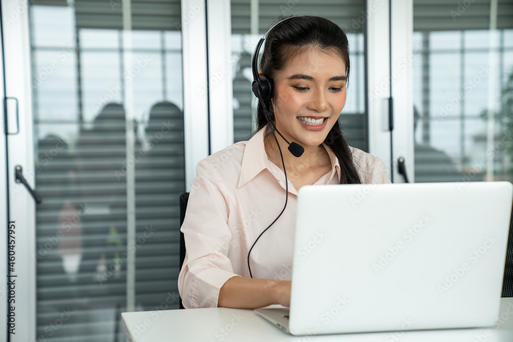 Businesswoman wearing headset working actively in office . Call center, telemarketing, customer supp