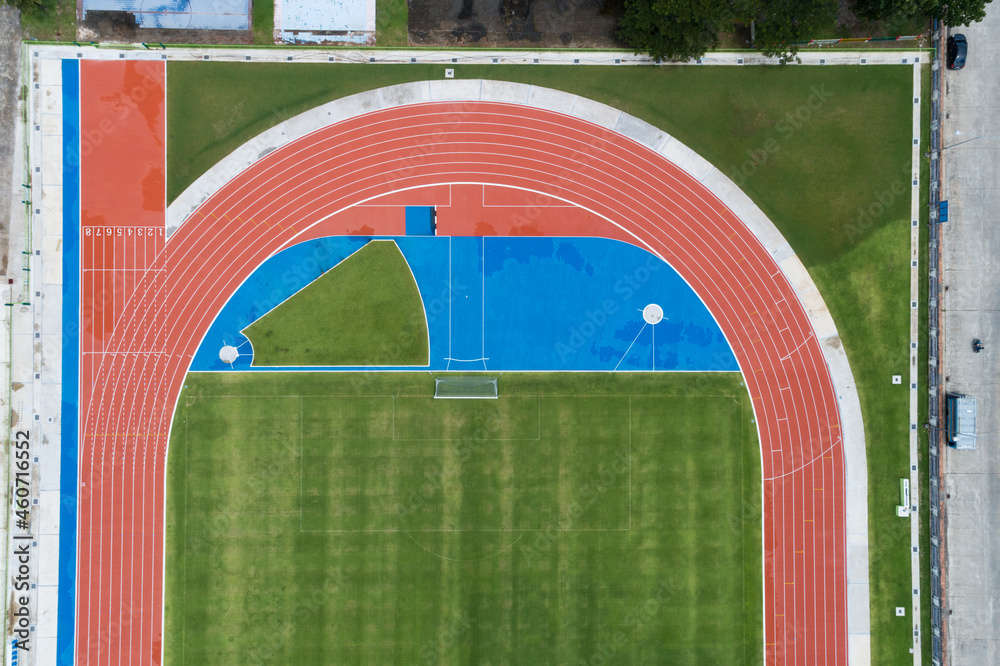 Aerial view of empty new soccer field from above with running tracks around it Amazing new small sta