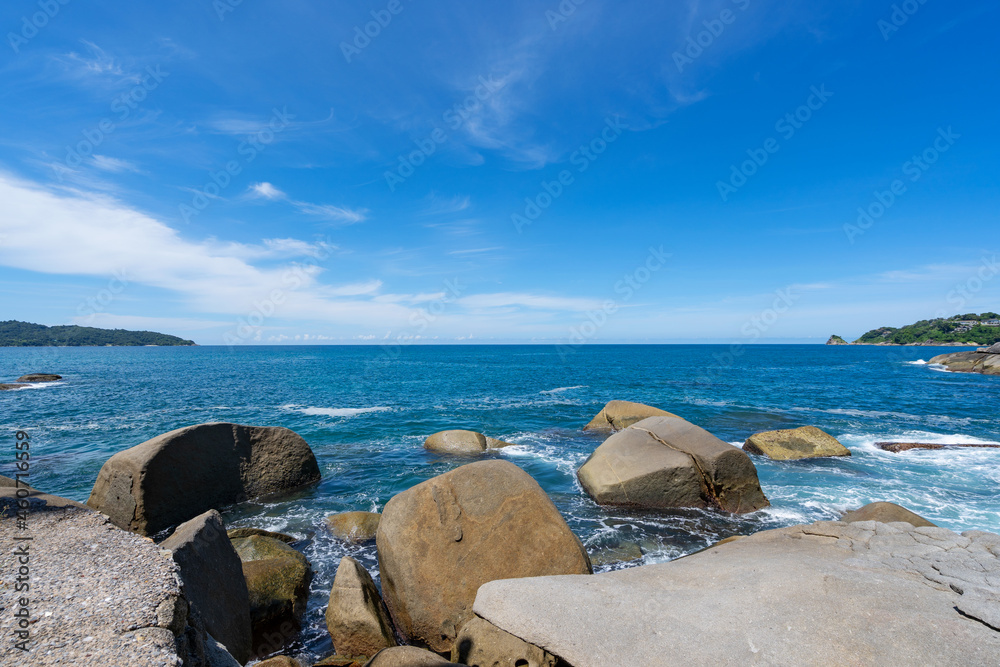 晴朗的蓝天下的岩石海岸，早晨有云夏季晴朗的日子背景美丽