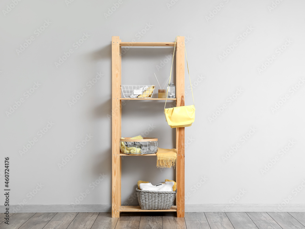 Shelf unit with wardrobe organizers near light wall