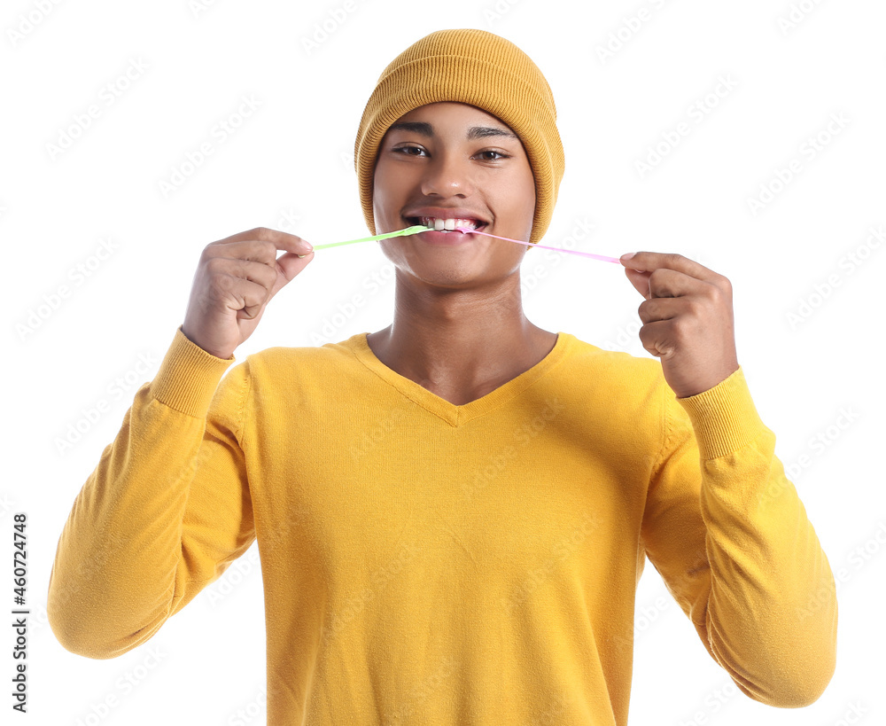 Happy African-American guy with chewing gum on white background