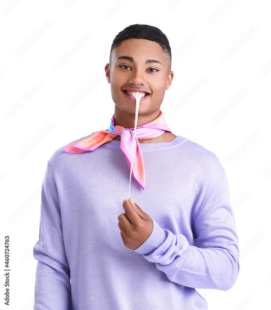 Happy African-American guy with chewing gum on white background