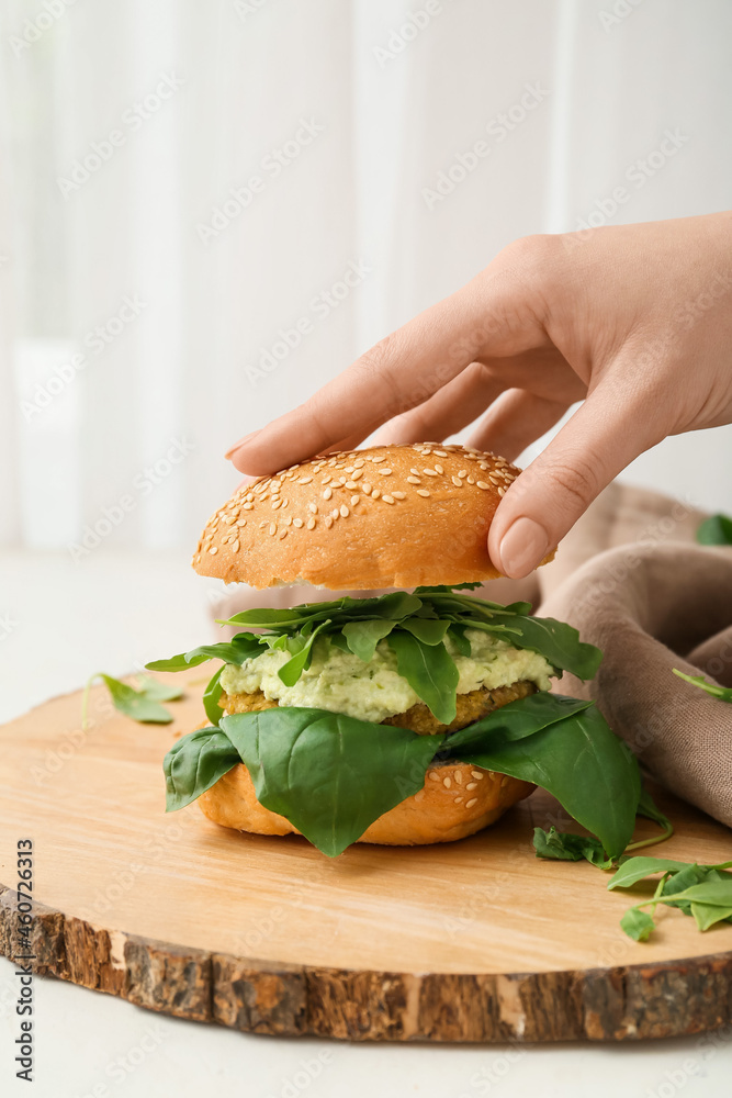 女人在餐桌上准备美味的素食汉堡