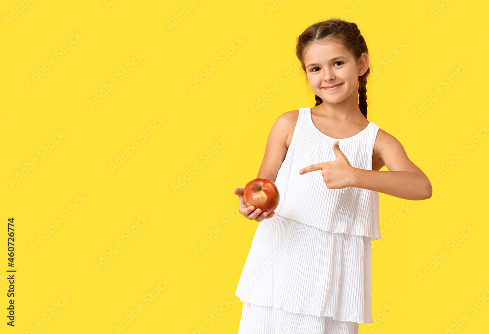 Little girl with apple on color background