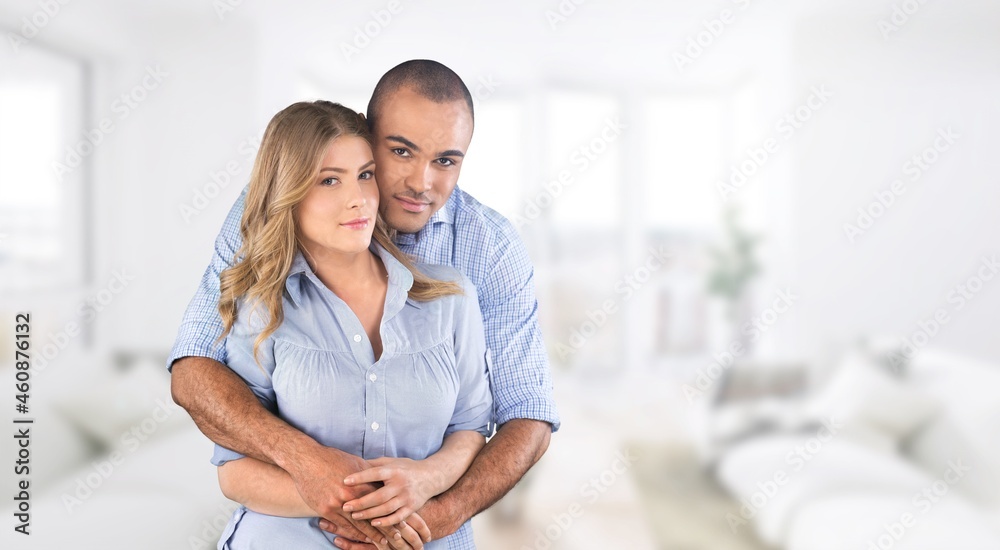 Smiling mid adult couple hugging each other and standing at home