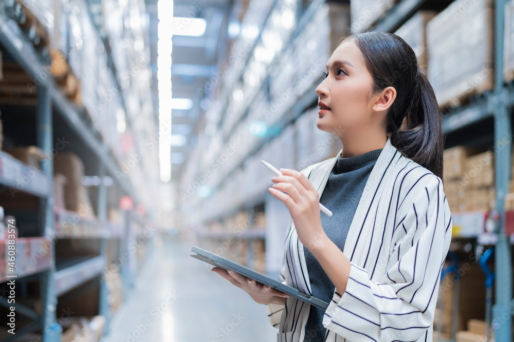 Portrait of asian woman business owner using digital tablet checking amount of stock product invento