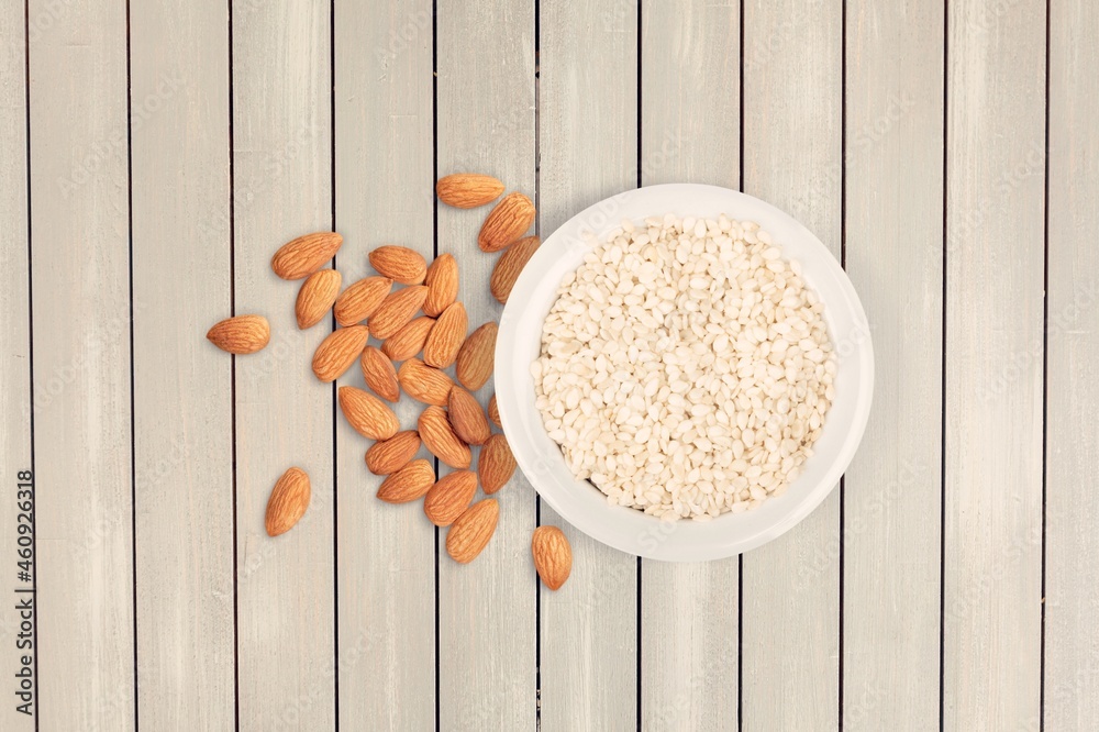 Almond flour in the bowl and almonds nut on the desk