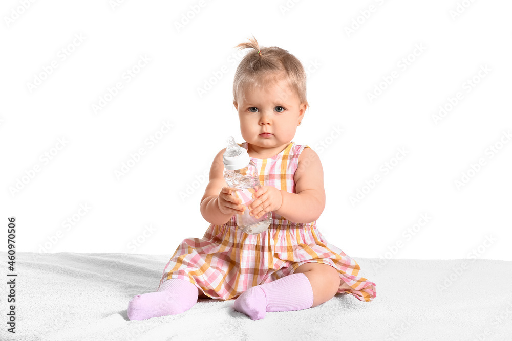 Cute baby girl with bottle of water on white background