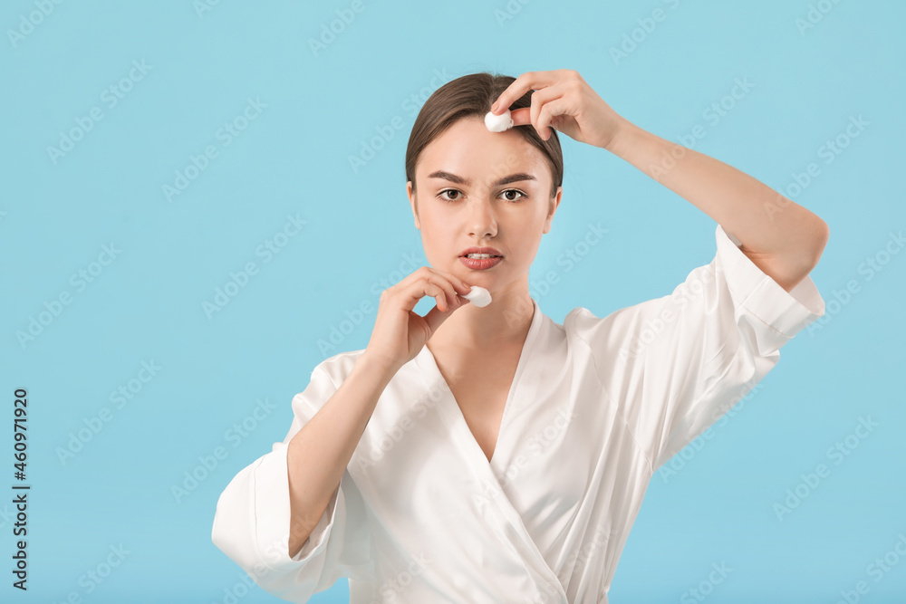 Beautiful young woman with cotton wool on color background