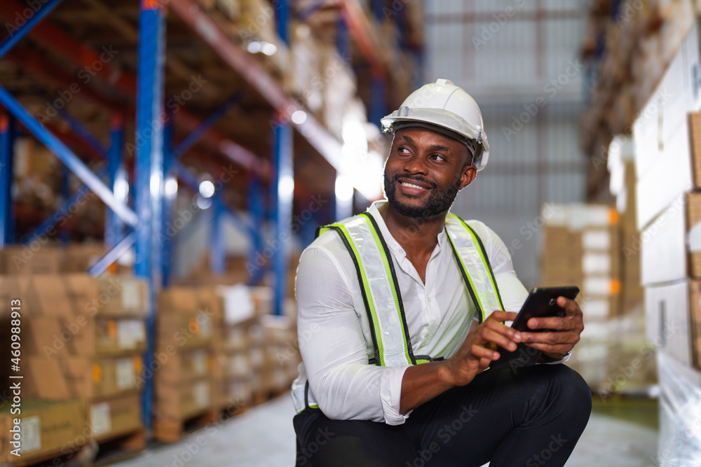 Warehouse worker working process checking the package with a tablet in a large distribution center. 