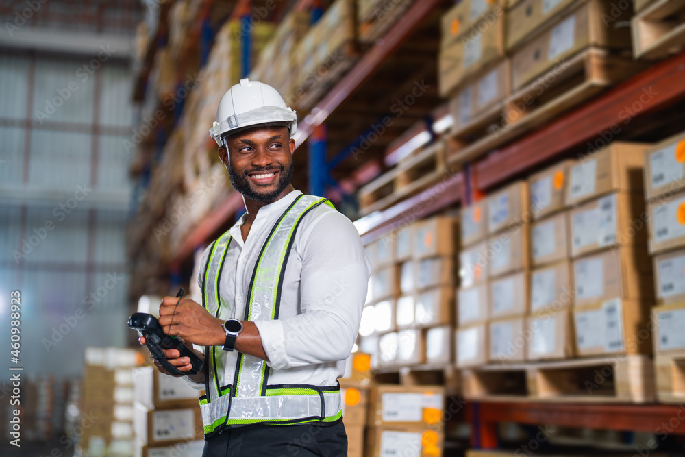 Warehouse worker working process checking the package with a barcode scanner in a large distribution