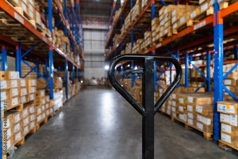 close up empty pallet truck handle standing in a distribution center warehouse