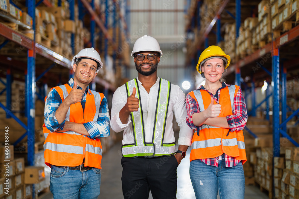 A small group of warehouse workers standing in a large distribution center. concept of teamwork and 