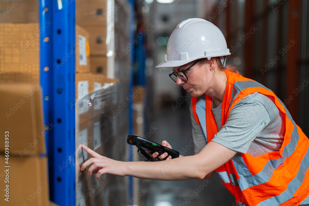 Warehouse worker working process checking the package using barcode reader in a large distribution c