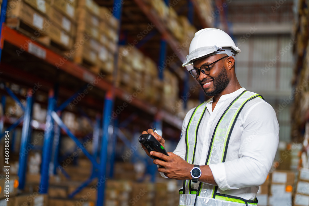 Warehouse worker working process checking the package with a barcode scanner in a large distribution