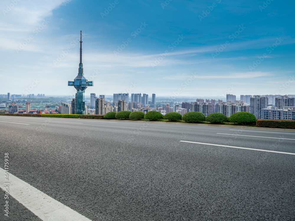 空旷的柏油路、城市天际线和建筑景观，中国。