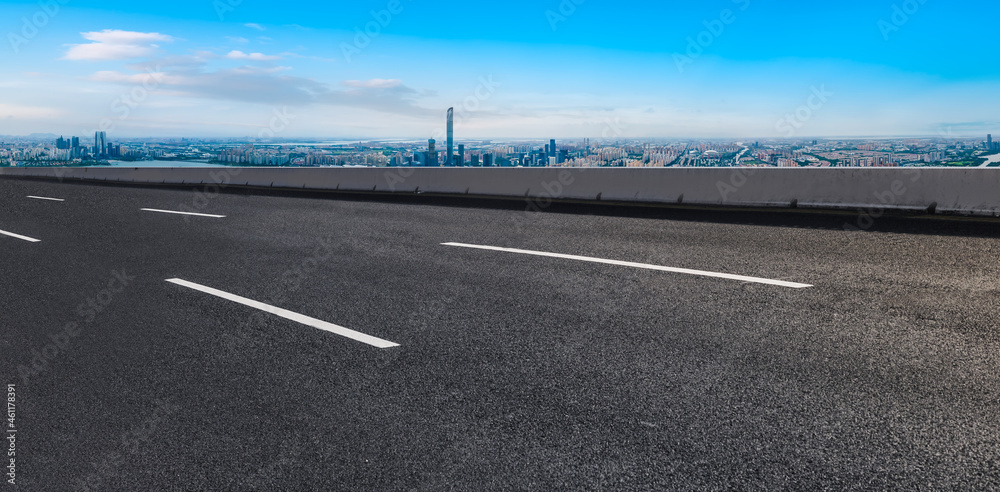 空旷的柏油路、城市天际线和建筑景观，中国。