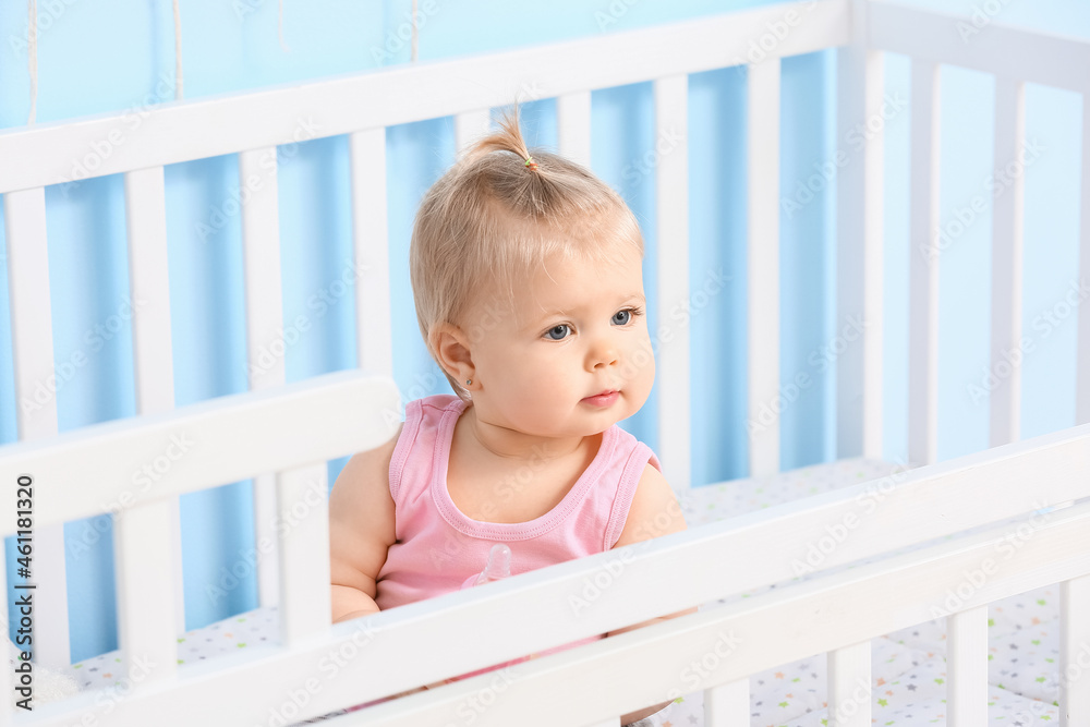 Cute baby girl in cot at home