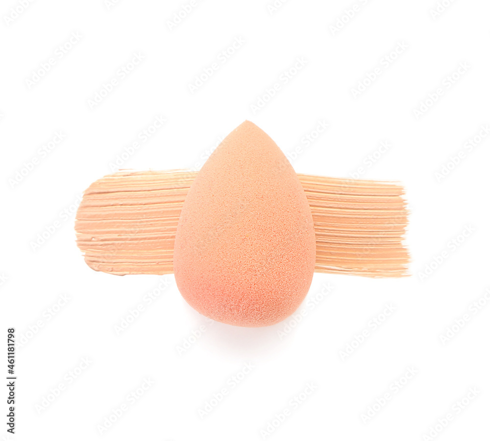 Stylish makeup sponge and foundation sample on white background