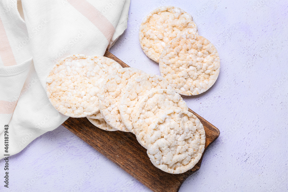 Board with crispy rice crackers on white background