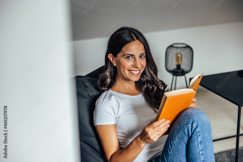 Adult woman, reading on her favorite chair.