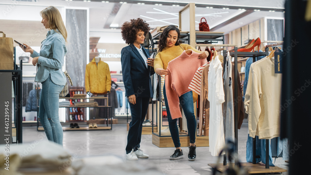 Customers Shopping in Modern Clothing Store, Retail Sales Associate Assists Client. Diverse People i