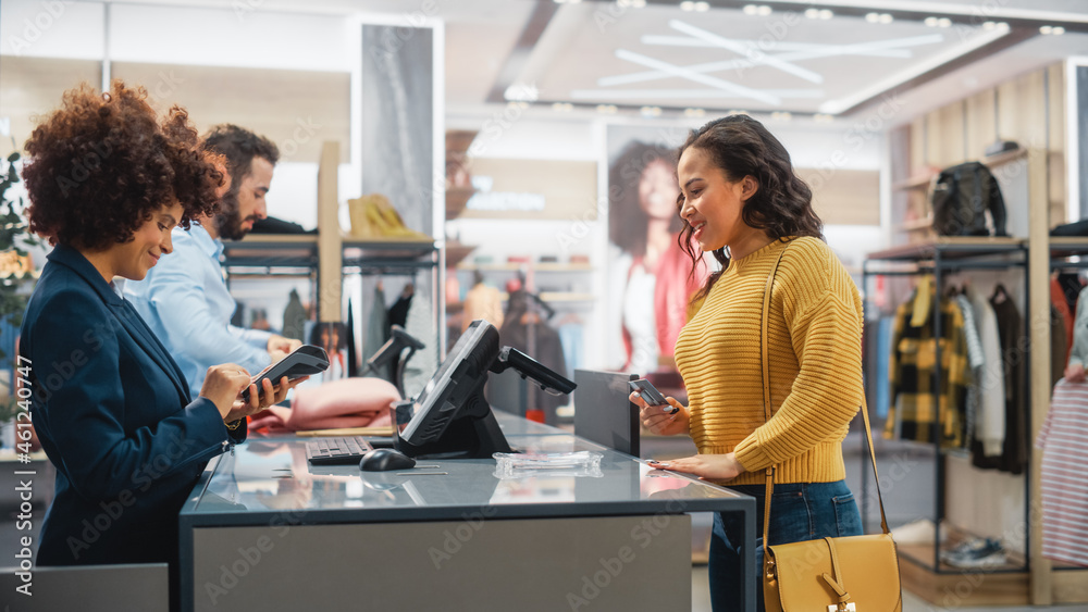 Clothing Store Checkout Cashier Counter: Woman and Male Retail Sales Managers Accept NFC Credit Card